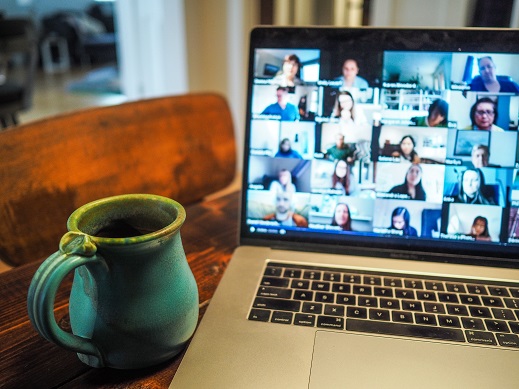 An open laptop reveals an online meeting in progress.
